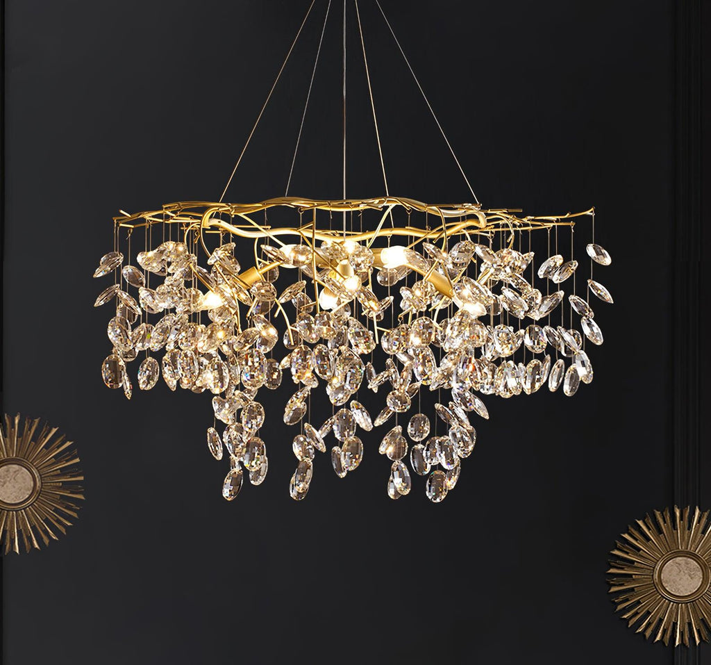 The chandelier lit on a black wall, flanked by two gold sunburst mirrors.