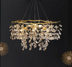 The chandelier lit on a black wall, flanked by two gold sunburst mirrors.