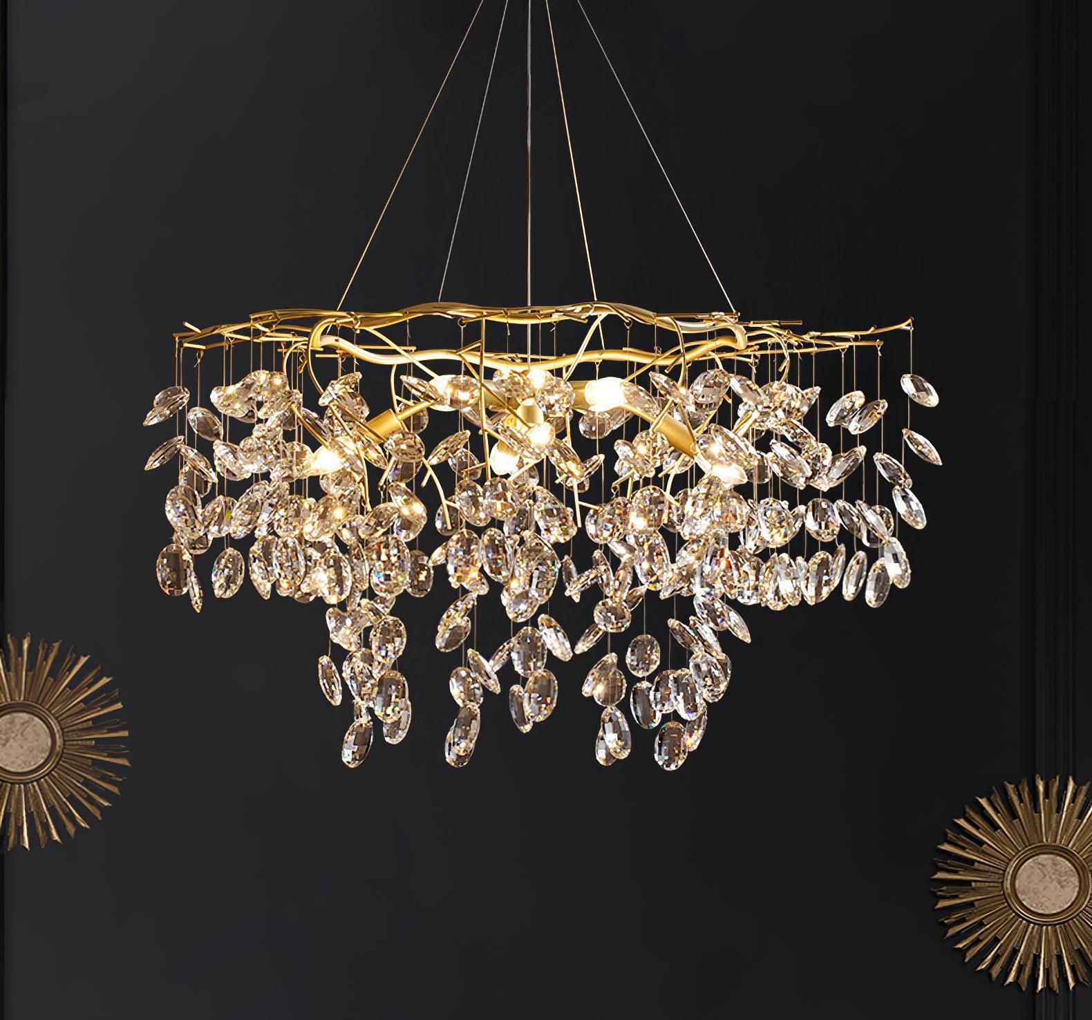The chandelier lit on a black wall, flanked by two gold sunburst mirrors.