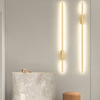 Black linear wall sconce glowing softly in a modern bedroom