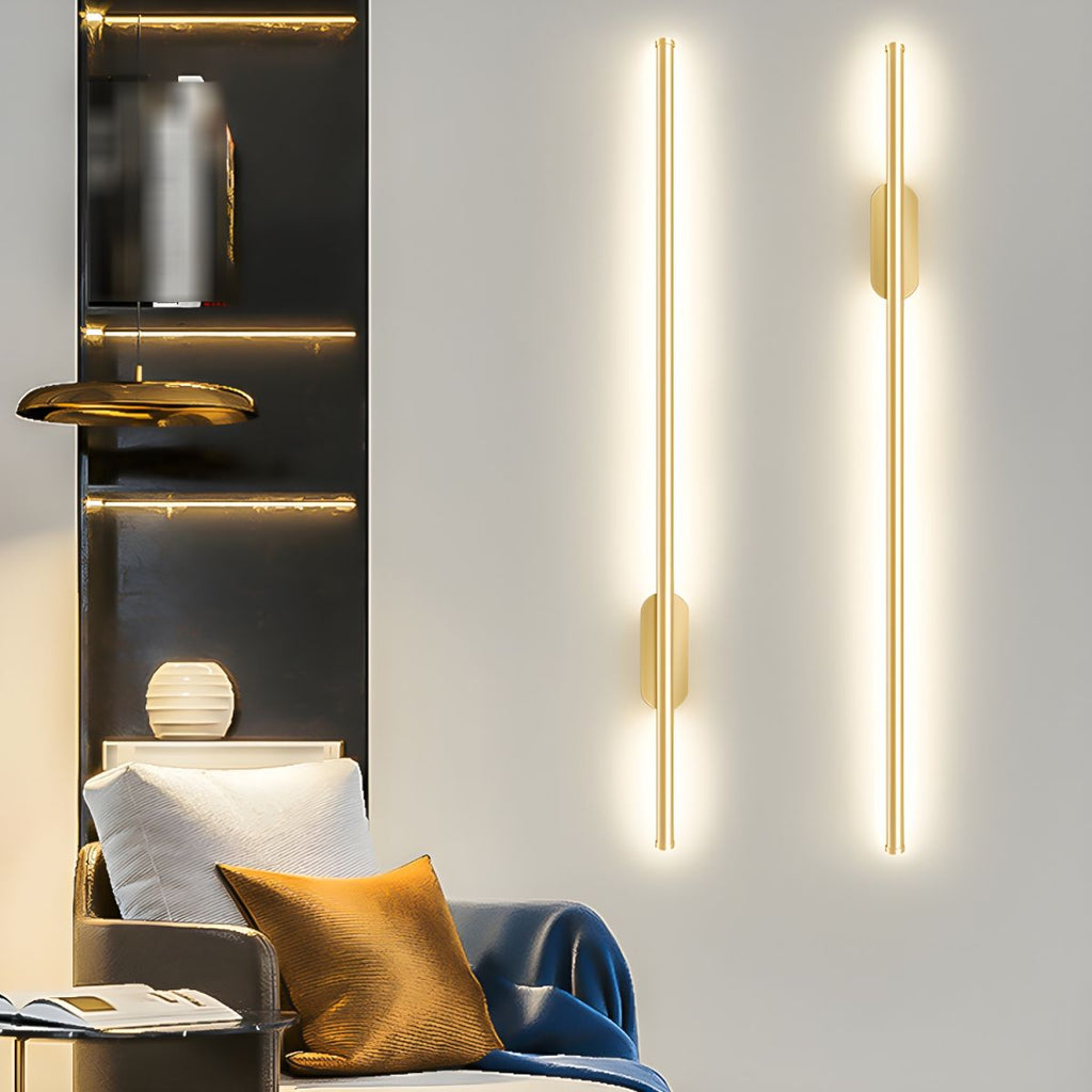 Gold linear sconce casting a warm vertical band of light