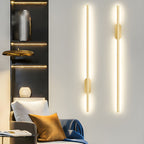 Gold linear sconce casting a warm vertical band of light