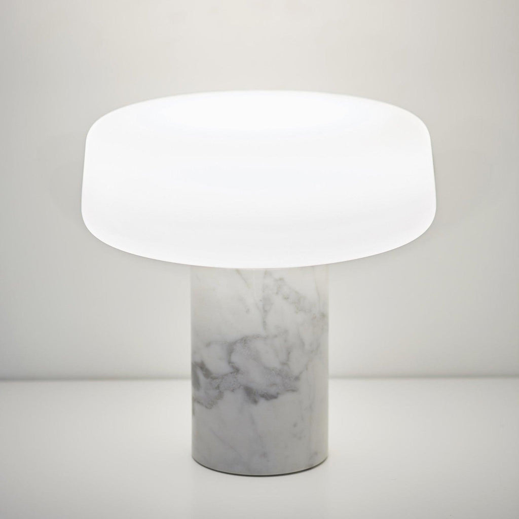 White marble Clérachic table lamp shown alone against a plain white background, its frosted glass shade catching the light.