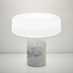White marble Clérachic table lamp shown alone against a plain white background, its frosted glass shade catching the light.