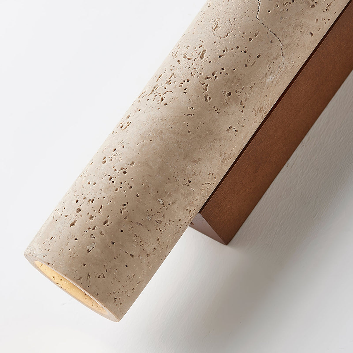 Close angled view of the travertine stone and walnut wood edge on this Clérachic wall light.