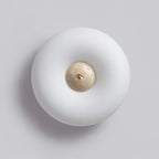 Clérachic ceiling light photographed off, from a raised angle, showing its rounded profile and brass-fitted stone centre.