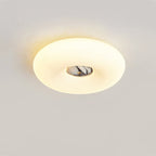 Clérachic ceiling light seen from a low angle, its oval glow and dark marbled stone centre lit against a grey wall.