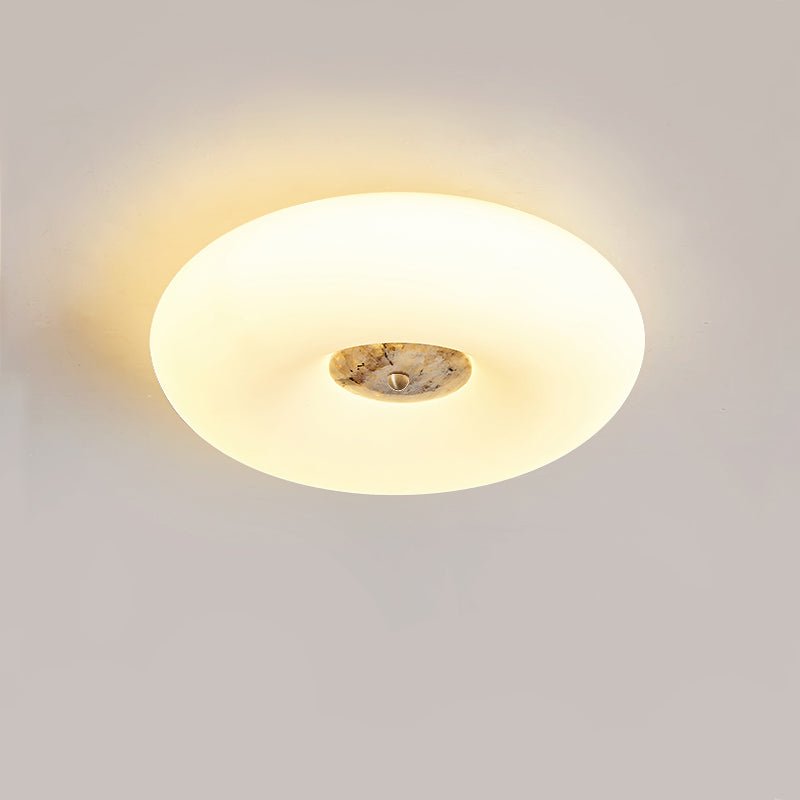Clérachic ceiling light in a round, symmetric crop, its tan stone centre glowing warmly against a grey backdrop.