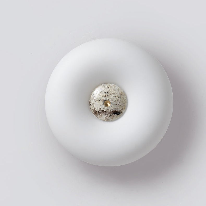 Clérachic ceiling light photographed from below at an angle, off, its donut profile and stone centre clearly visible.