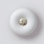 Clérachic ceiling light photographed from below at an angle, off, its donut profile and stone centre clearly visible.