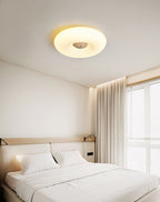 Clérachic ceiling light lit above a bed with a wood-slat headboard and a small swing-arm reading lamp fitted to it.