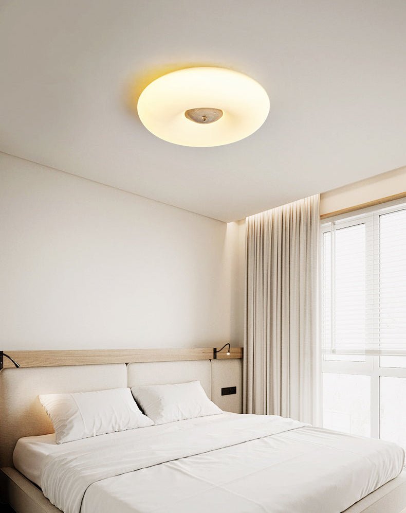 Clérachic ceiling light lit above a bed with a wood-slat headboard and a small swing-arm reading lamp fitted to it.