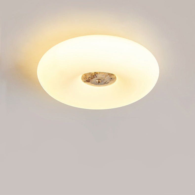 Clérachic ceiling light lit in close crop, sheer curtains and a radiator visible in the softly lit room below.