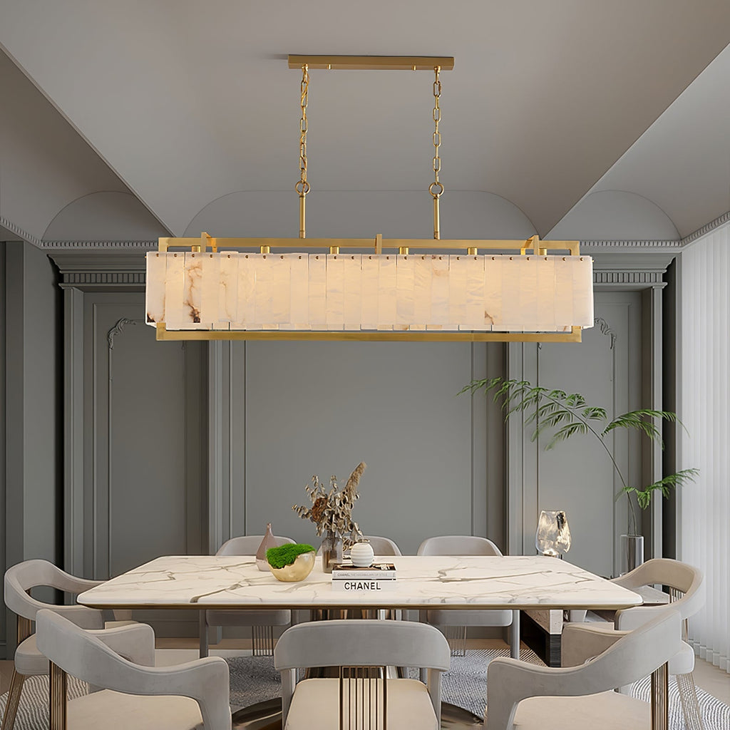 Lit above a marble table in an arched grey room, books and a plant on the table below.