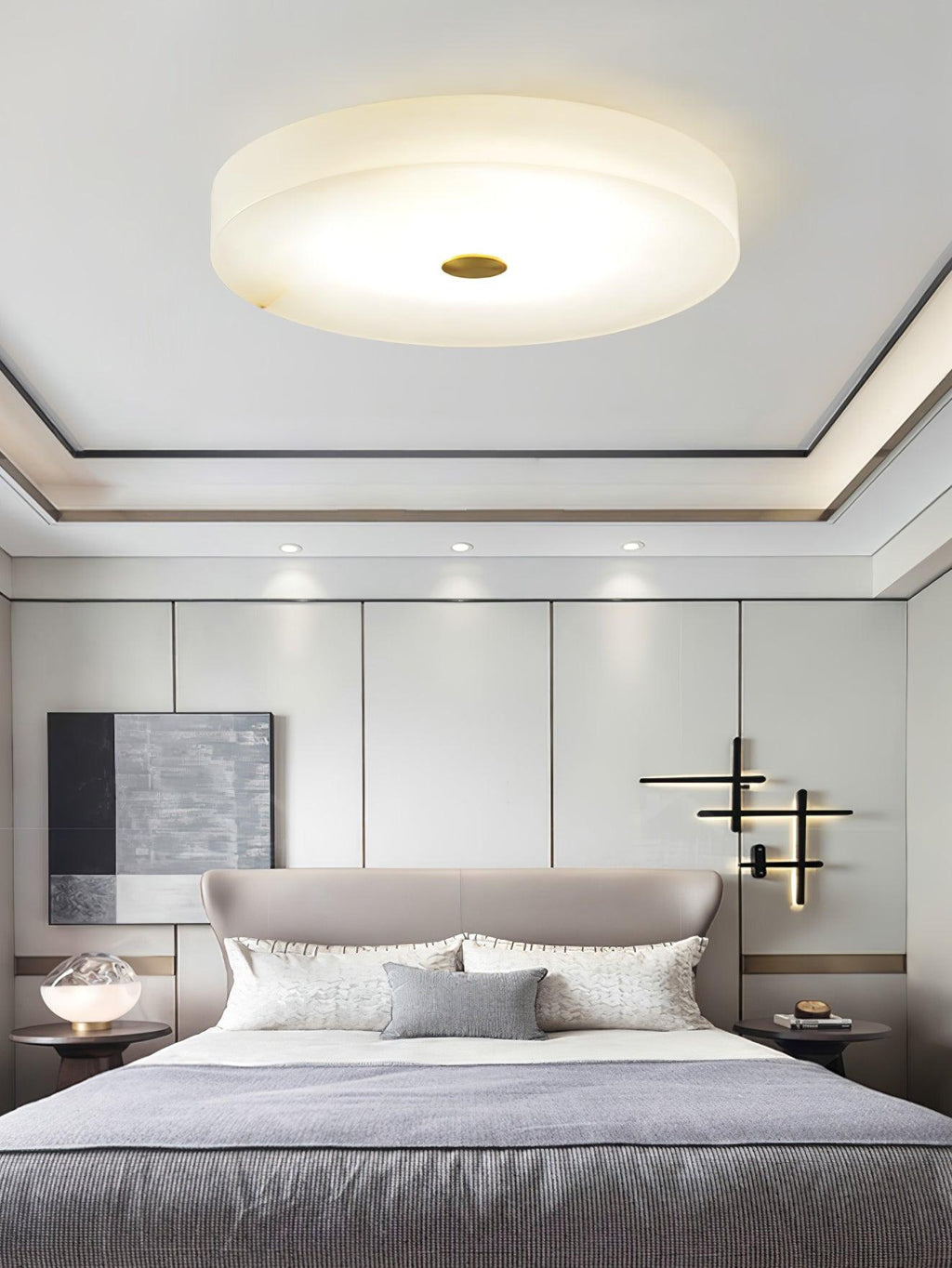 The Olaean flush mount lit above a bed, sitting flat against a recessed tray ceiling.