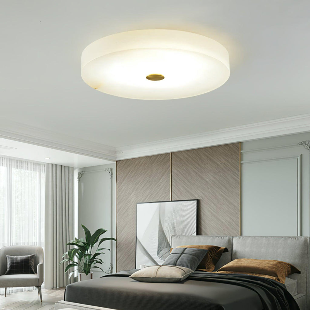 Wider view of the lit Olaean flush mount in a bedroom with panelled walls and soft daylight.