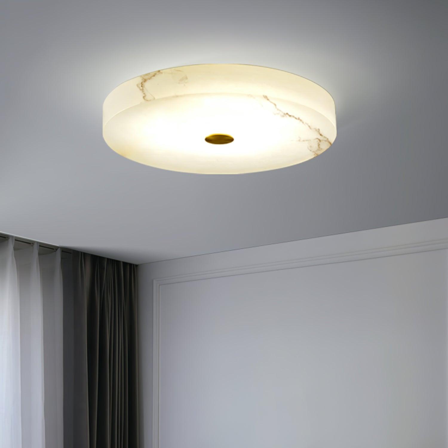 Olaean flush mount lit near a corniced wall, warm veins running across the alabaster shade.