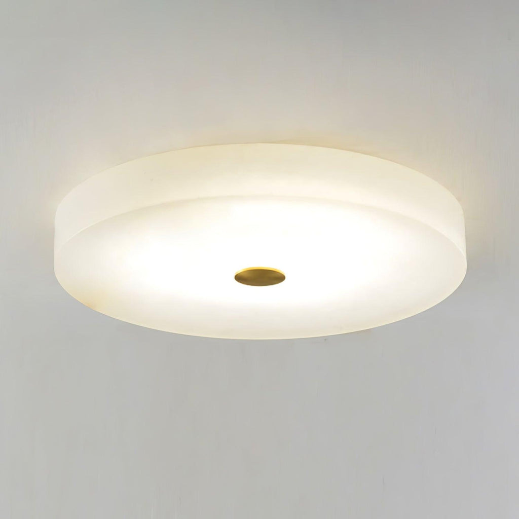 Close view of the Olaean flush mount in use, light pooling evenly across the alabaster disc.