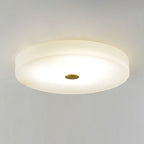 Close view of the Olaean flush mount in use, light pooling evenly across the alabaster disc.