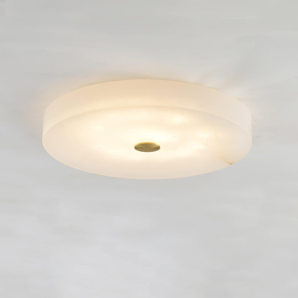 Olaean flush mount lit from a low angle, showing the stepped edge of the alabaster drum.