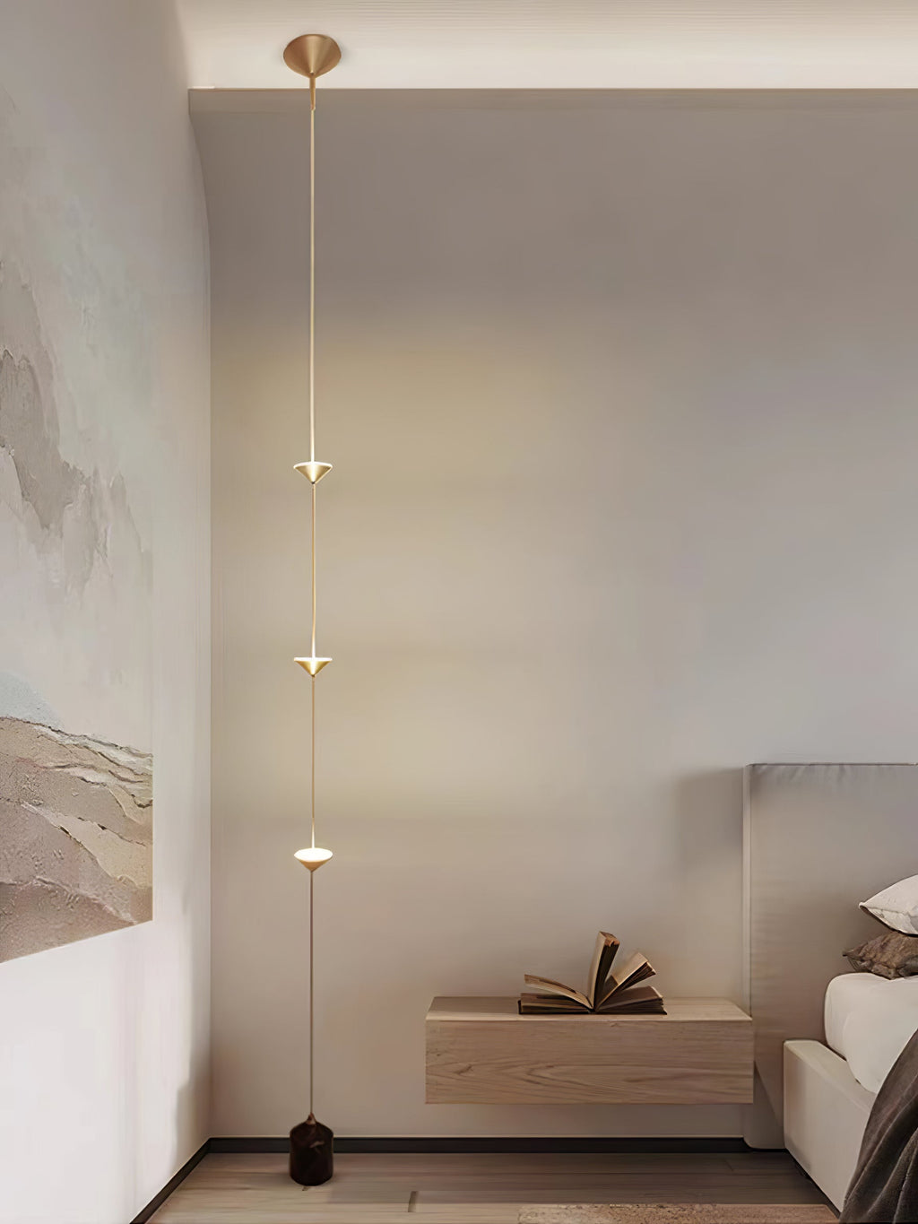 Floor lamp with gold conical shades against a dark backdrop