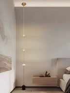 Floor lamp with gold conical shades against a dark backdrop