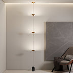 Floor lamp with gold shades beside seating in an interior
