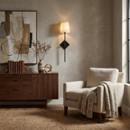Beside a walnut credenza and abstract wire art, this Clérachic sconce in matte black lights a cream armchair with a throw.