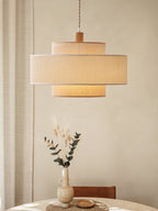 This Clérachic pendant hangs above a linen-draped side table topped with a vase of dried grasses.