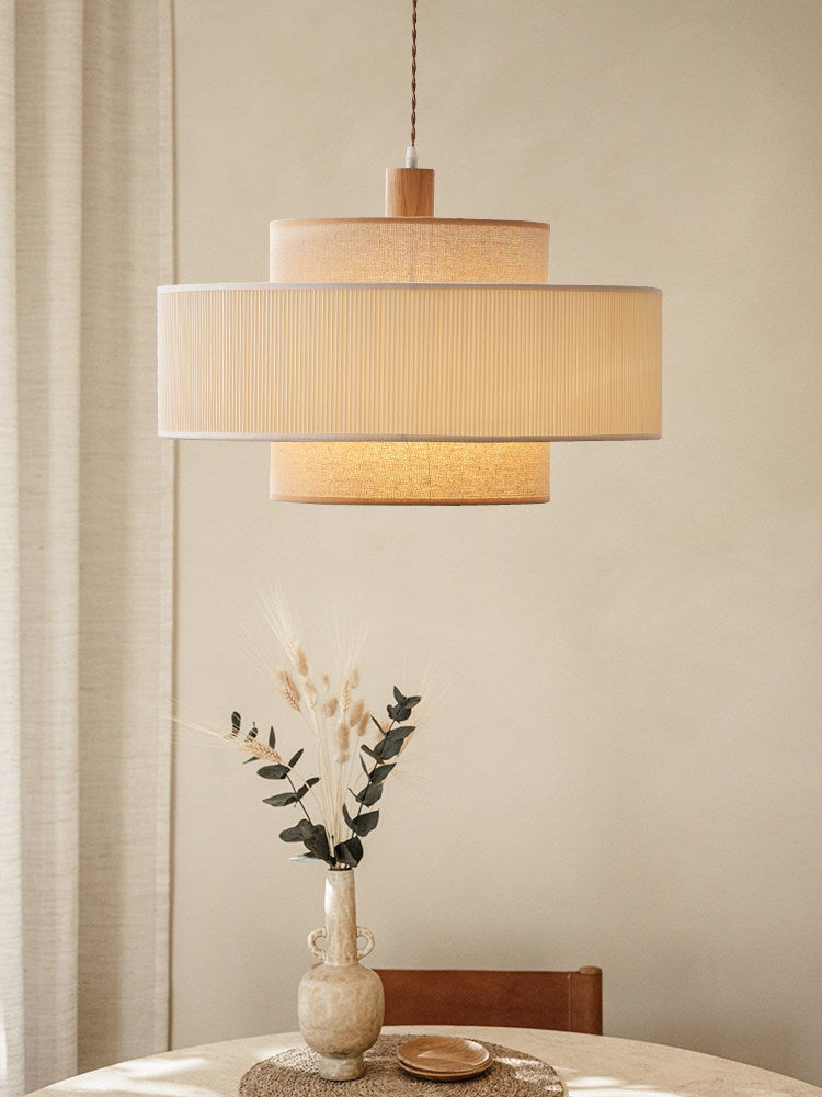 This Clérachic pendant hangs above a linen-draped side table topped with a vase of dried grasses.