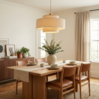 This Clérachic pendant, with a narrow pleated band above a wider drum, hangs over a wood dining table set with leather chairs.