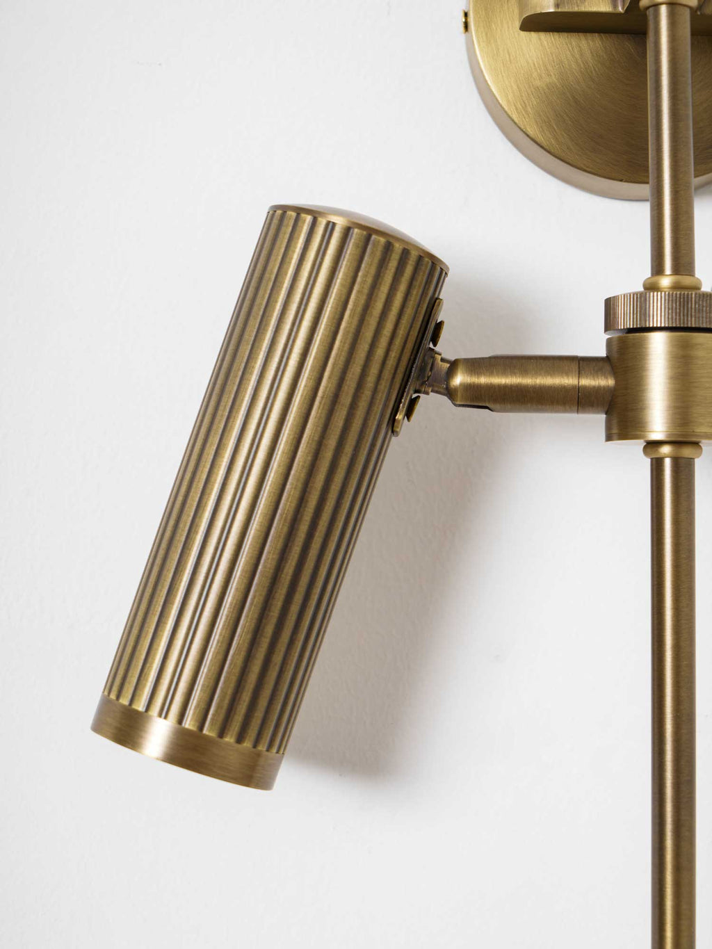 Close view of one ribbed head on this Clérachic plug-in spotlight in bronze finish, its swivel joint visible.