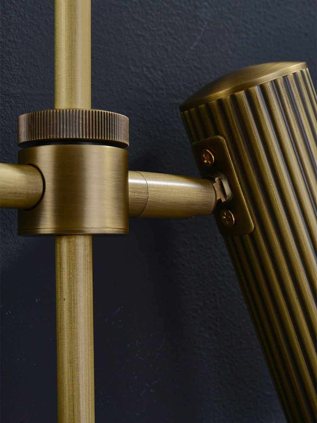 Detail of the swivel joint on this Clérachic plug-in spotlight in bronze finish, connecting head to rail.