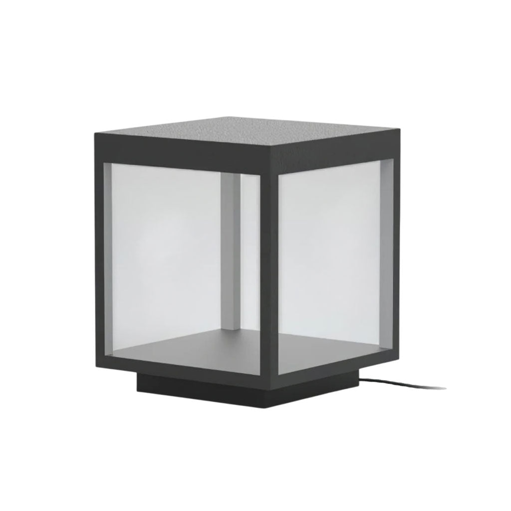 Square outdoor post light shown lit beside a fence