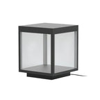 Square outdoor post light shown lit beside a fence
