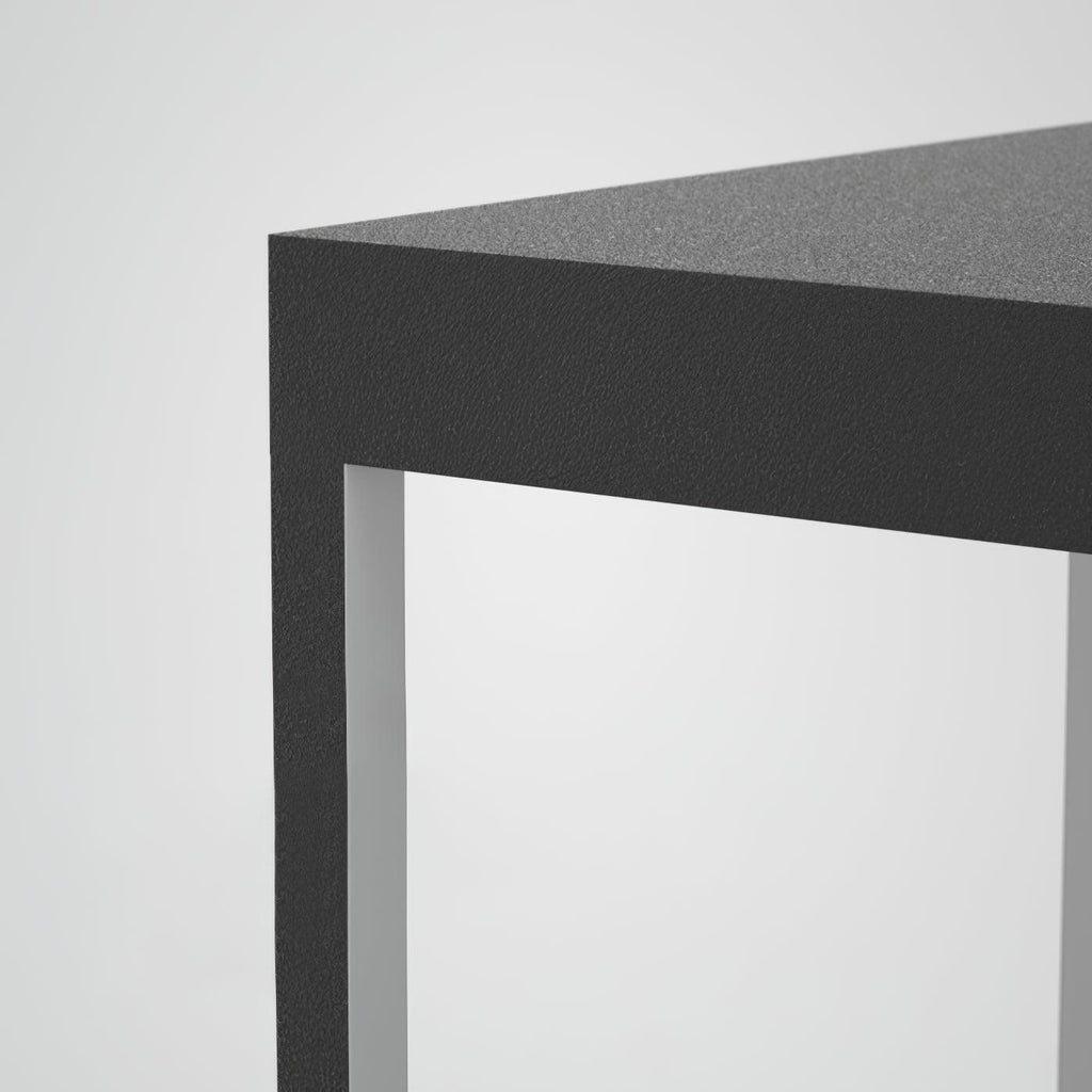 Square stainless steel outdoor light glowing on a terrace
