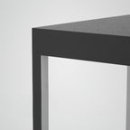Square stainless steel outdoor light glowing on a terrace