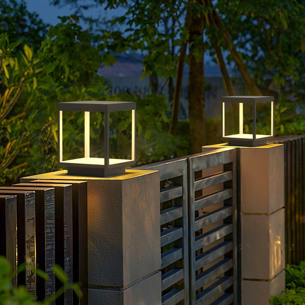 Outdoor post light casting warm light across a garden bed