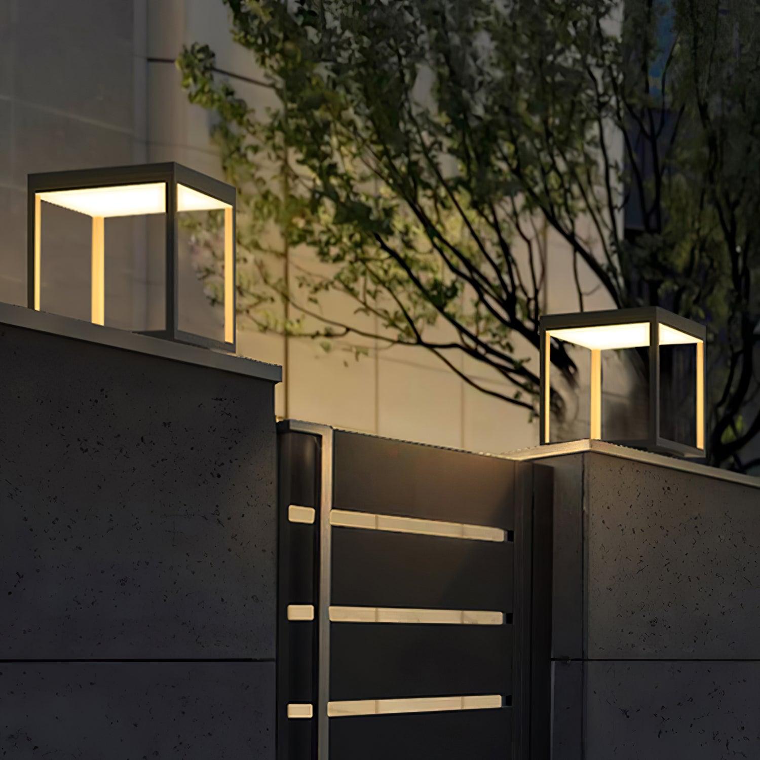 Square stainless steel outdoor light glowing along a path