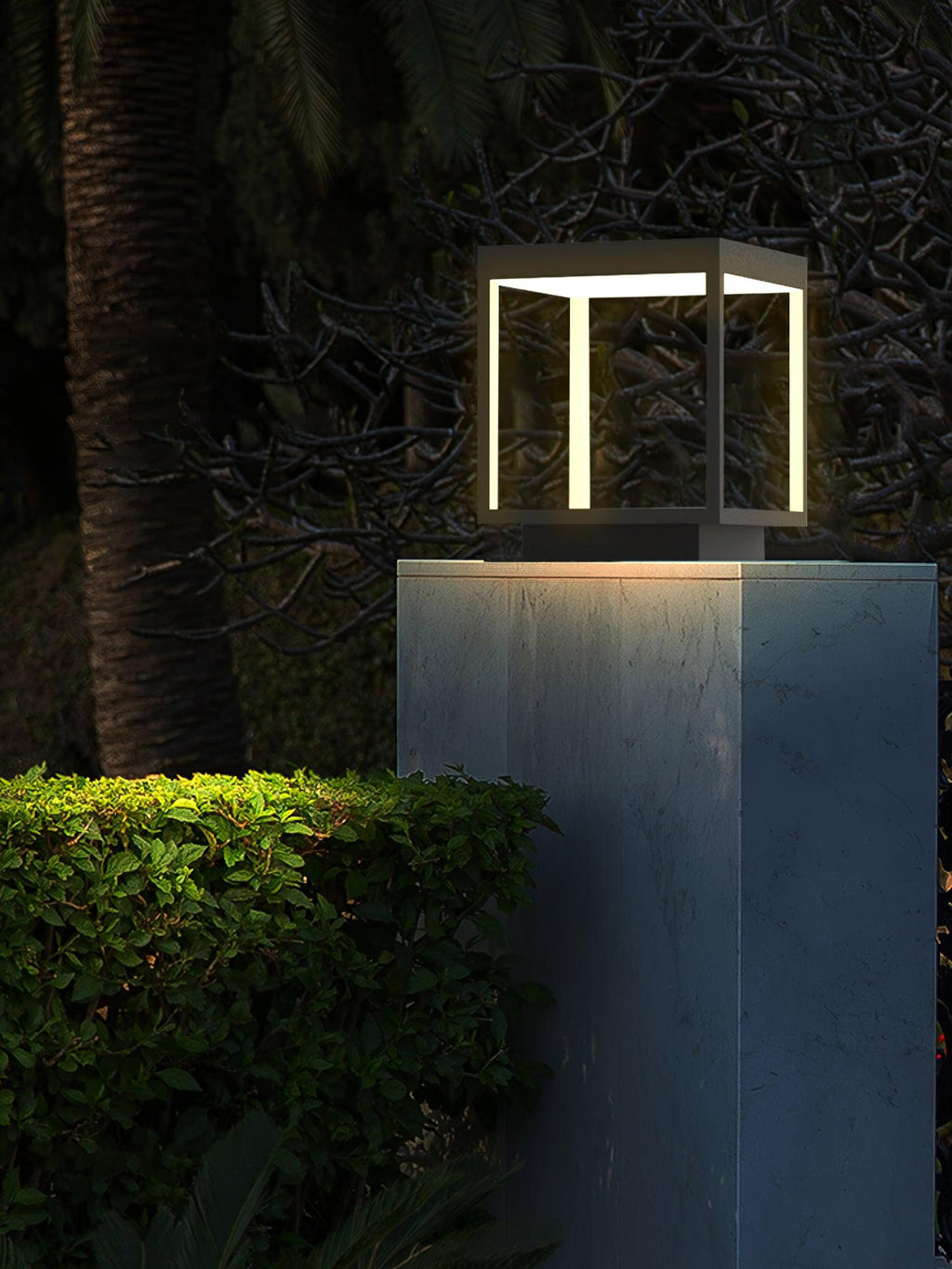 Outdoor post light glowing along a fence line at dusk