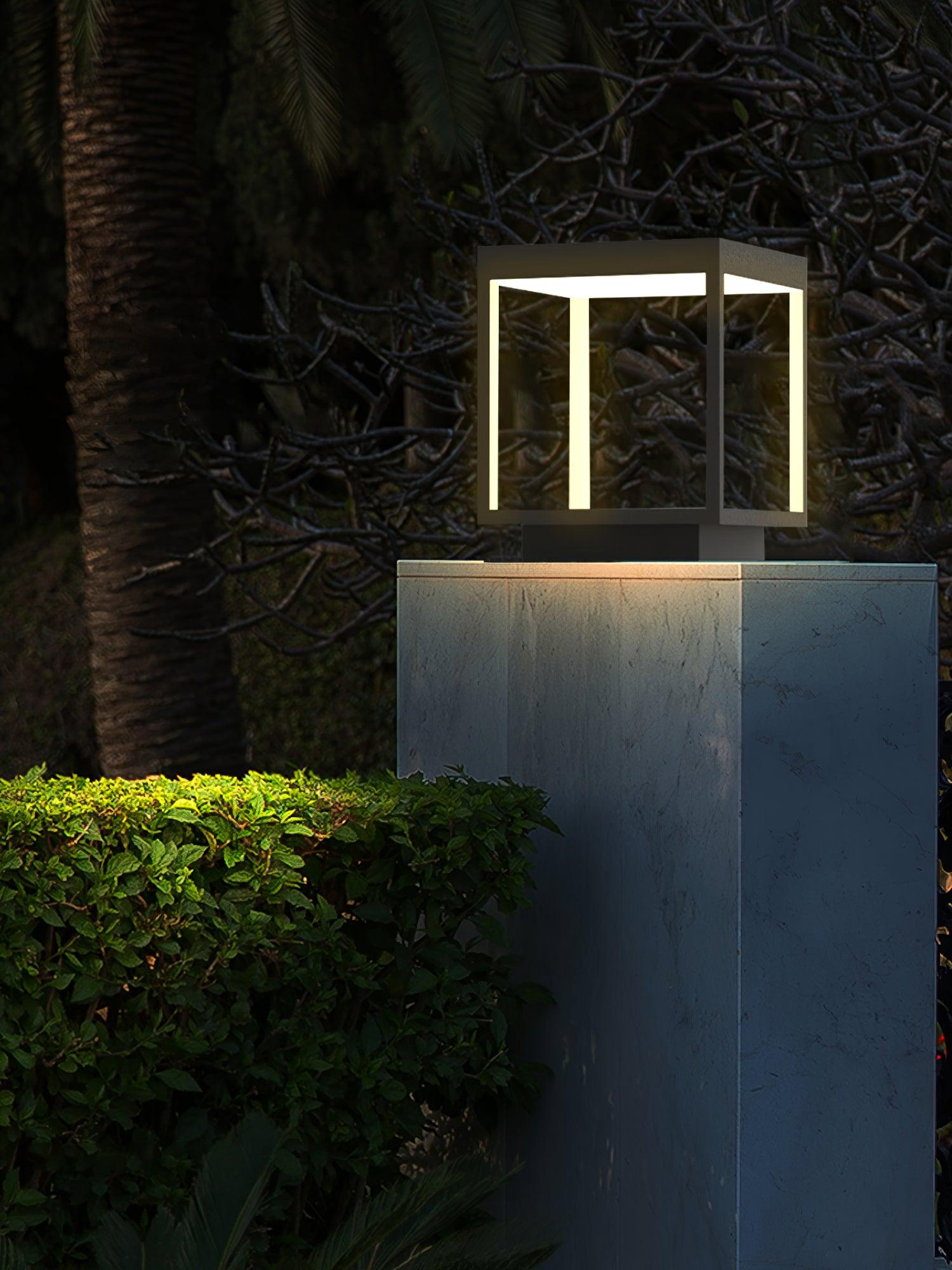 Outdoor post light glowing along a fence line at dusk