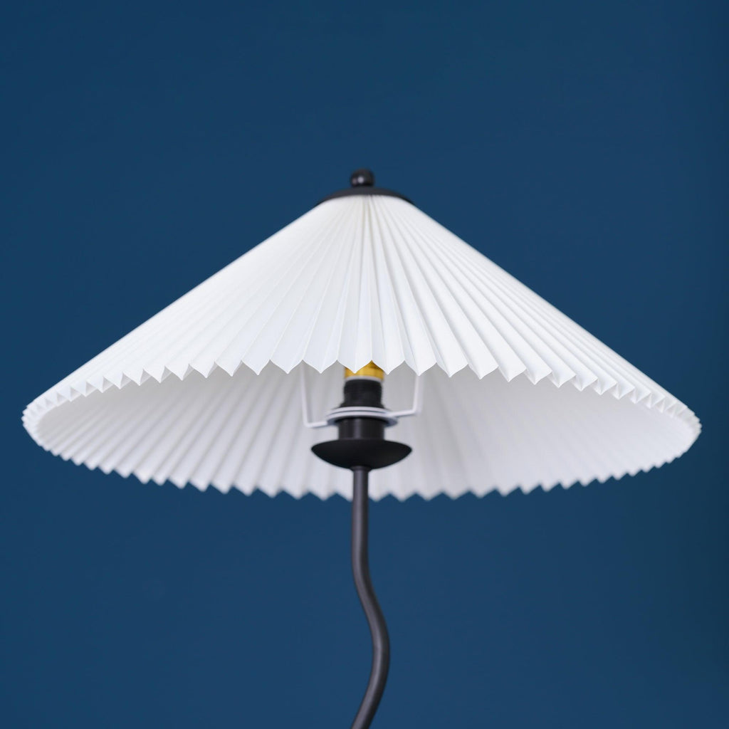 Squiggle floor lamp lit beside a reading chair