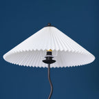 Squiggle floor lamp lit beside a reading chair