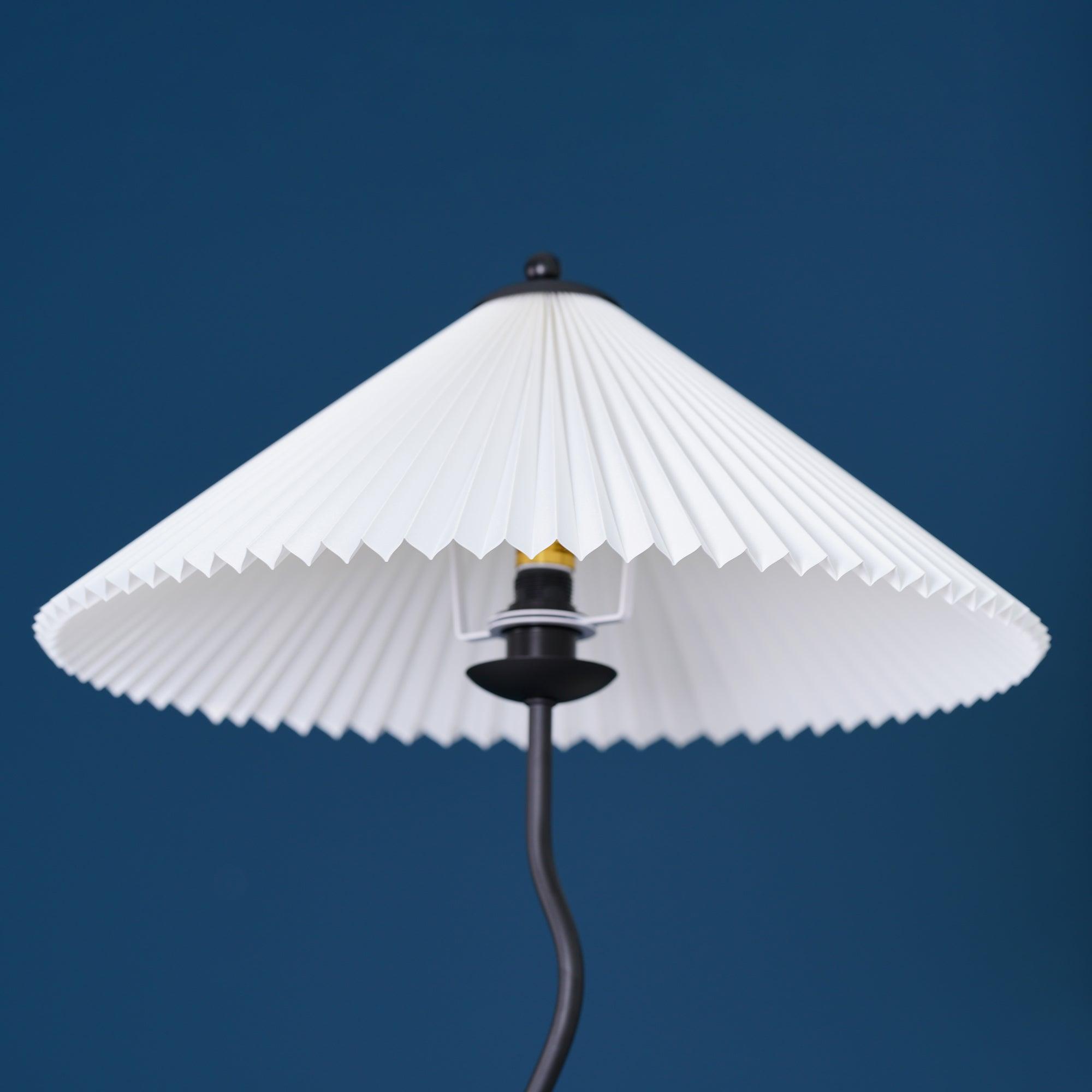Squiggle floor lamp lit beside a reading chair