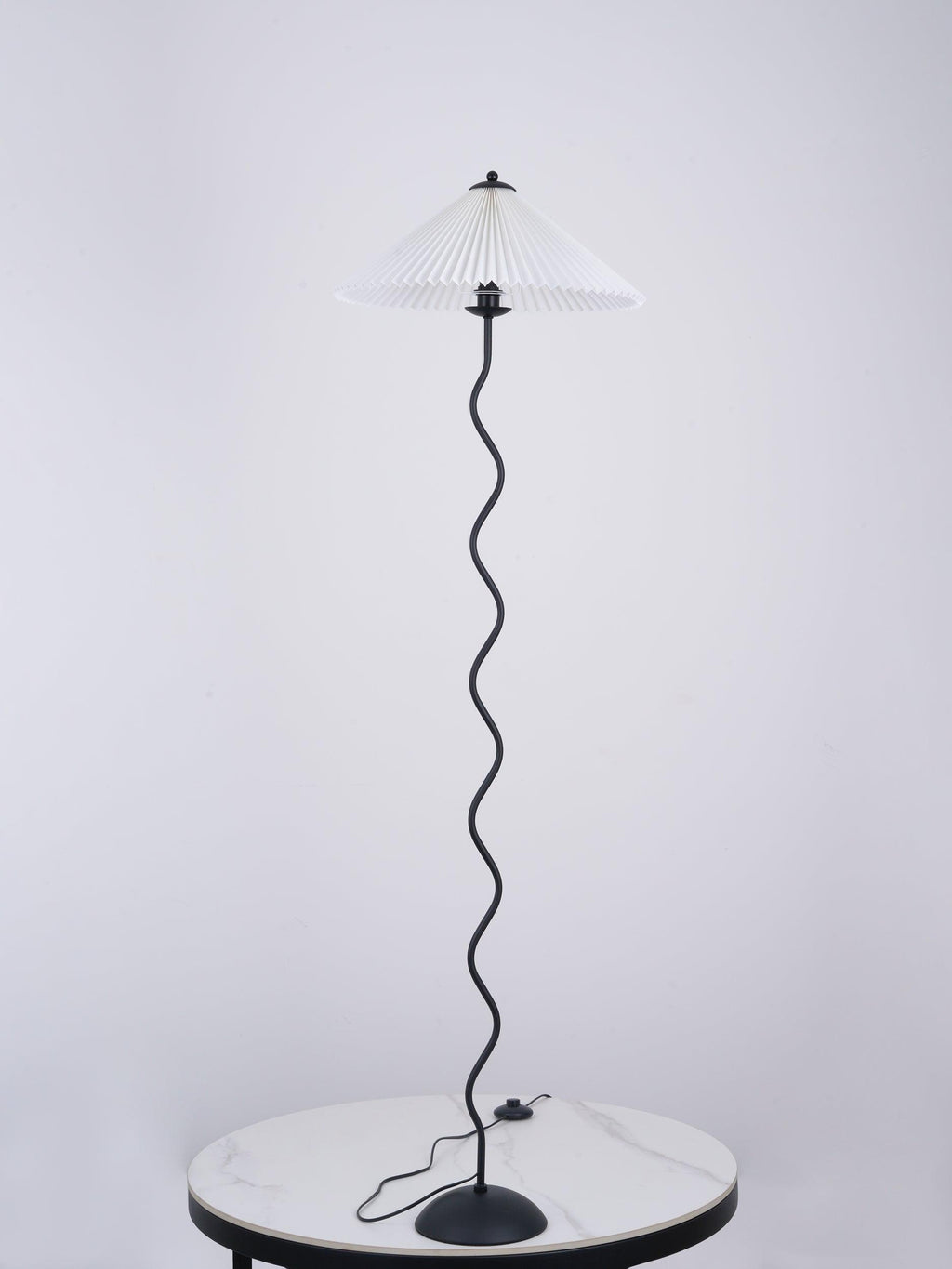Squiggle floor lamp with dark fabric shade in a styled room