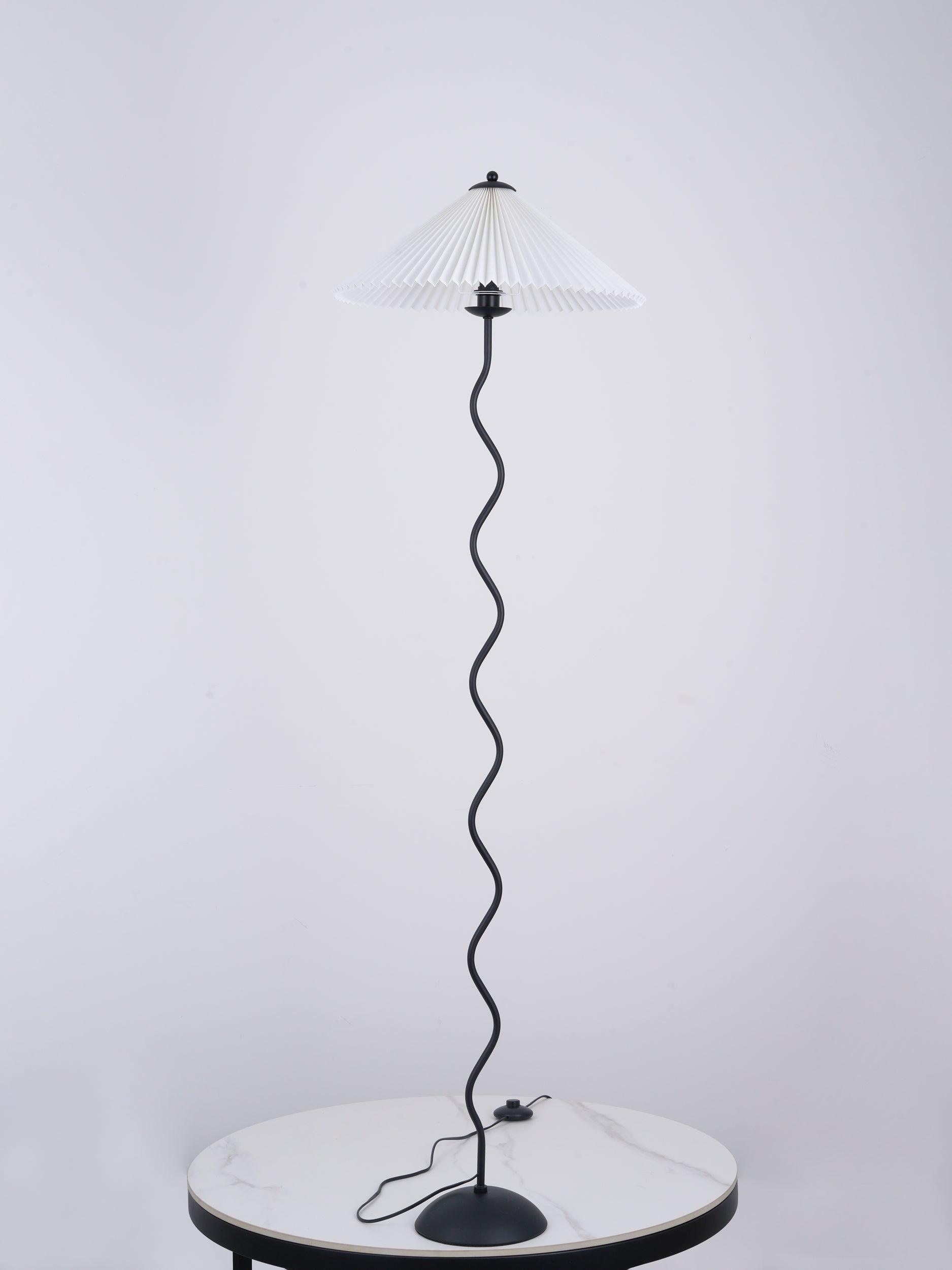 Squiggle floor lamp with dark fabric shade in a styled room