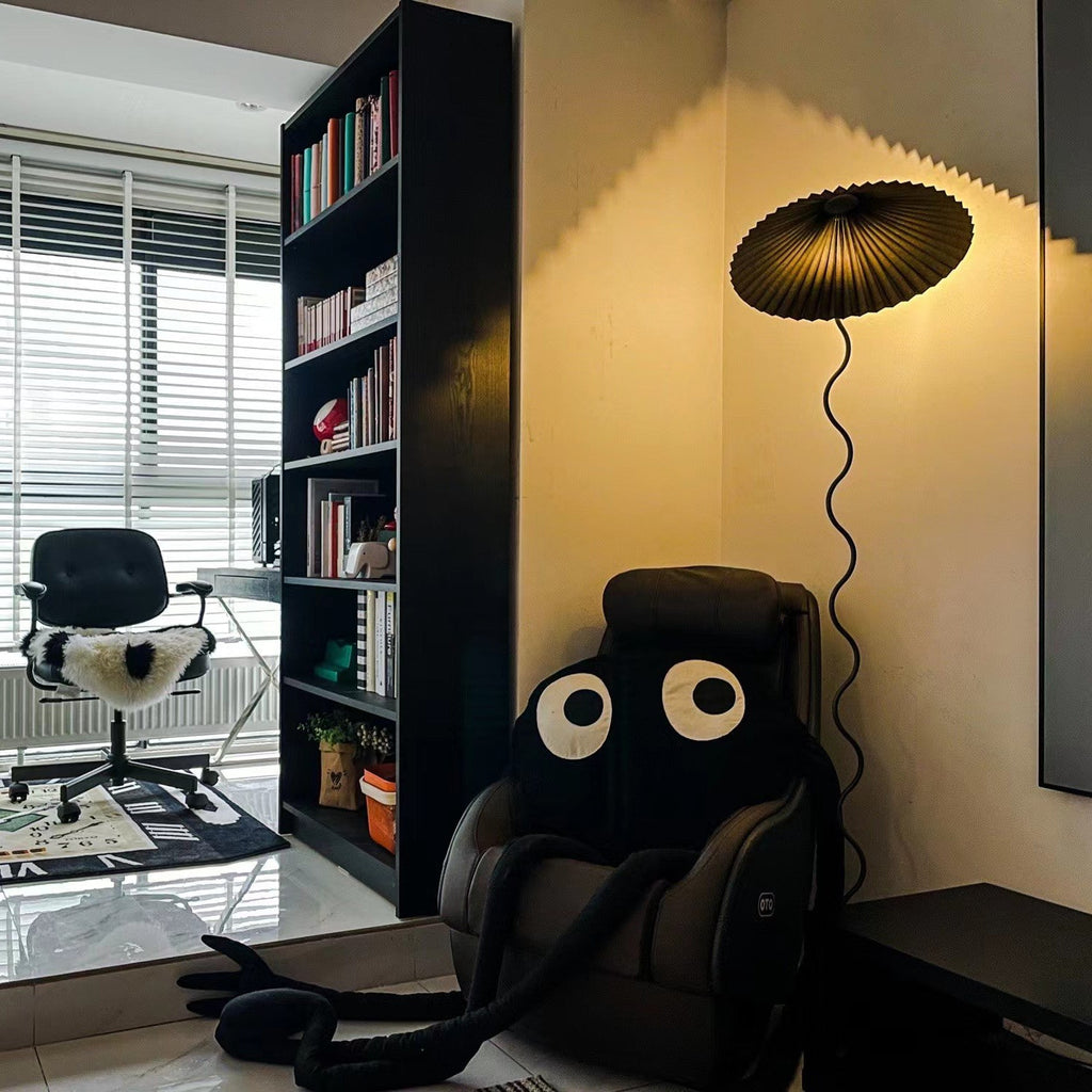 Squiggle floor lamp with fabric shade glowing softly at night