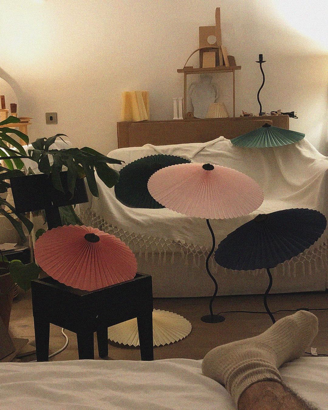 Squiggle table lamp on a surface with pleated shade detail