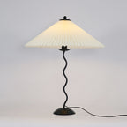 Squiggle table lamp viewed straight on with pleated shade