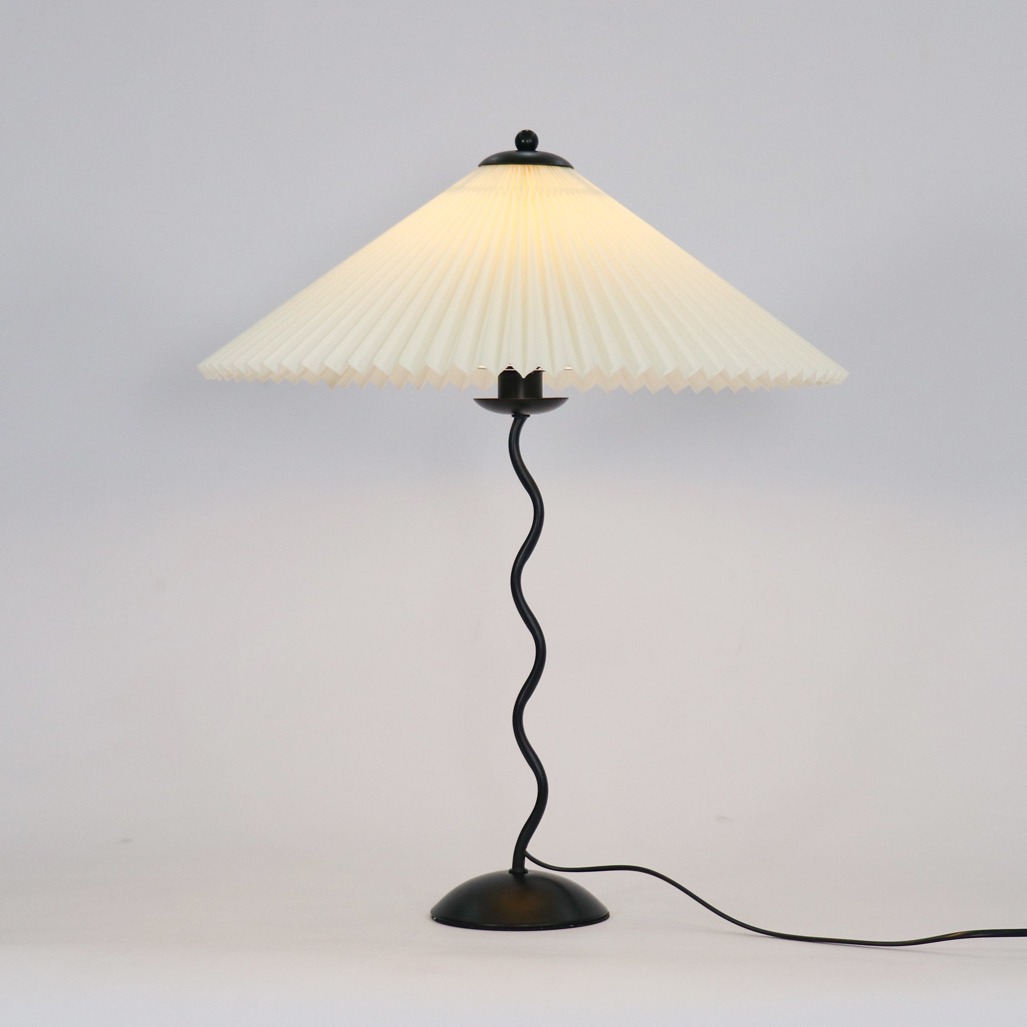 Squiggle table lamp viewed straight on with pleated shade